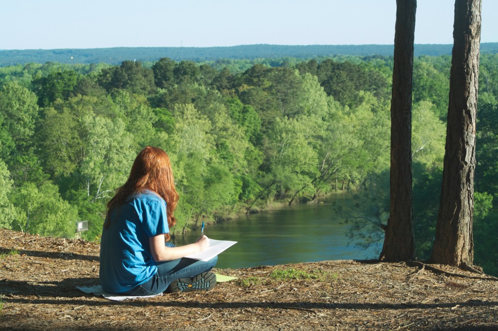 Junior Jessica Saunders works on a writing assignment on a field trip to DeSoto Bluff for Children's Literature class. Photo by Laken Livingston.